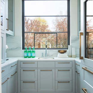 Aménagement d'une arrière-cuisine classique en U avec un évier encastré, un placard à porte shaker, une crédence en fenêtre, un sol en bois clair et un sol beige.