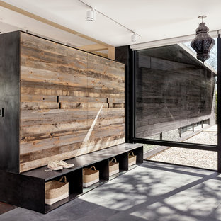 オースティンの大きい片開きドアモダンスタイルのおしゃれなマッドルーム (濃色木目調のドア、黒い壁) の写真