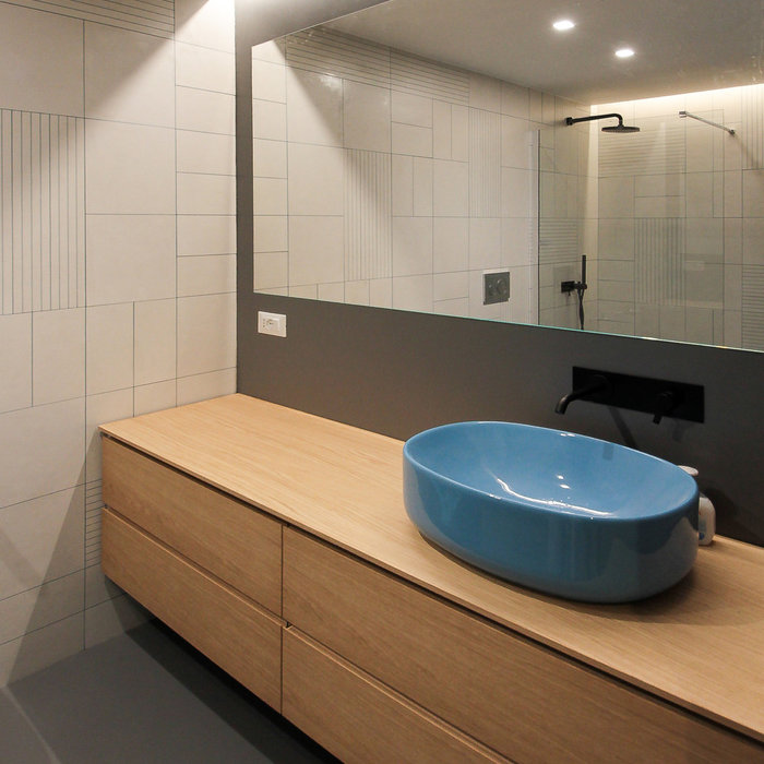 L'area lavabo è caratterizzata da un grande mobile con cassetti in legno di rovere, su cui poggia una bacinella colore turchese della casa NIC DESIGN, e da un grande specchio che occupa l'intera largh
