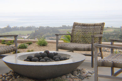 Patio - mid-sized modern backyard stone patio idea in Santa Barbara with a fire pit and no cover