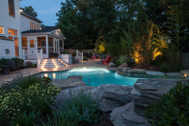 This is an example of a small eclectic backyard custom-shaped natural pool in DC Metro with a water feature and concrete pavers.