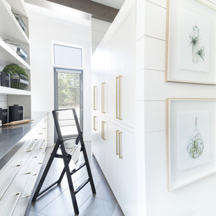 Стильный дизайн: кухня в стиле современная классика с кладовкой, белыми фасадами, столешницей из нержавеющей стали, белым фартуком, фартуком из плитки кабанчик и серым полом - последний тренд