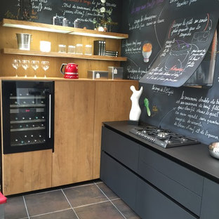 Huge contemporary kitchen pantry pictures - Example of a huge trendy u-shaped kitchen pantry design in Lyon with medium tone wood cabinets, laminate countertops, black backsplash and black appliances