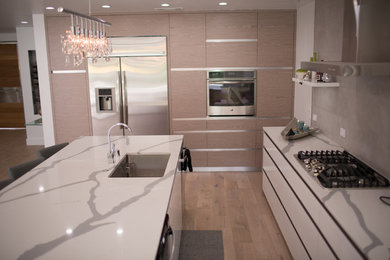 Open concept kitchen - mid-sized modern single-wall bamboo floor and brown floor open concept kitchen idea in Seattle with a double-bowl sink, open cabinets, white cabinets, quartzite countertops, gray backsplash, marble backsplash, stainless steel appliances and an island