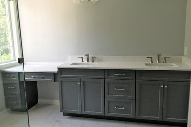 Example of a mid-sized classic master porcelain tile bathroom design in Charlotte with gray cabinets, an undermount sink, a hinged shower door, recessed-panel cabinets and quartz countertops