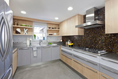 Inspiration for a transitional u-shaped kitchen in New York with stainless steel appliances, stainless steel benchtops, an integrated sink, flat-panel cabinets, grey cabinets and multi-coloured splashback.
