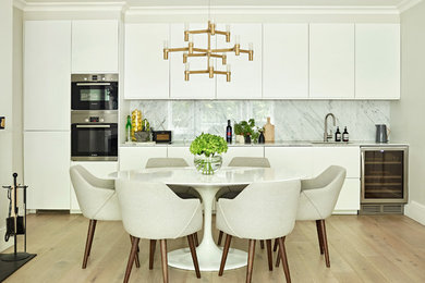 Photo of a contemporary kitchen/dining combo in London with beige walls, light hardwood floors and beige floor.