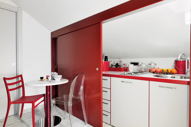 This is an example of a small contemporary single-wall separate kitchen in Turin with a drop-in sink, flat-panel cabinets, white cabinets, laminate benchtops, porcelain floors, white splashback, no island and grey floor.