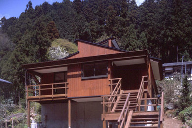 Foto de fachada de casa marrón y gris nórdica de dos plantas con revestimiento de madera, tejado a dos aguas, tejado de metal y panel y listón