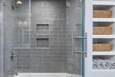 This is an example of a contemporary bathroom in New York with an open shower, gray tile, porcelain tile and grey walls.