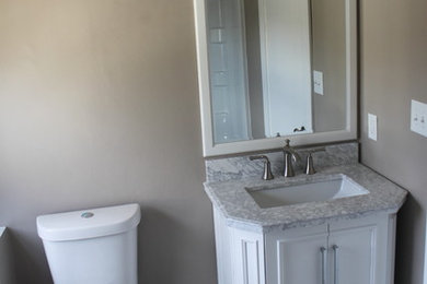 Example of a mid-sized classic 3/4 black and white tile and ceramic tile ceramic tile bathroom design in Grand Rapids with an undermount sink, recessed-panel cabinets, white cabinets, marble countertops, a two-piece toilet and beige walls