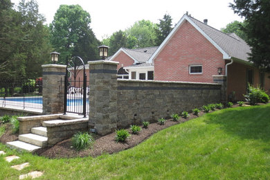 Design ideas for a mid-sized traditional backyard custom-shaped natural pool in Chicago with concrete pavers.