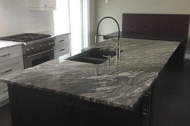 Mid-sized transitional l-shaped dark wood floor and brown floor open concept kitchen photo in Toronto with a double-bowl sink, recessed-panel cabinets, white cabinets, granite countertops, white backsplash, ceramic backsplash, stainless steel appliances, an island and gray countertops