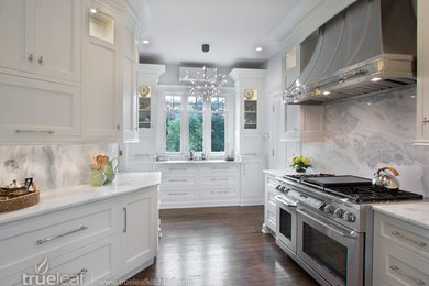 Example of a transitional dark wood floor eat-in kitchen design in New York with beaded inset cabinets, white cabinets, marble countertops, gray backsplash, stone slab backsplash and paneled appliances