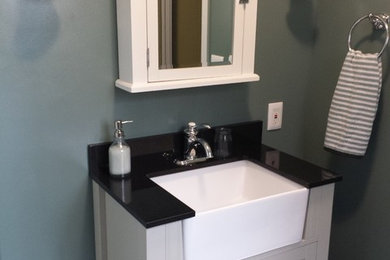 Example of a cottage corner shower design in Omaha with granite countertops