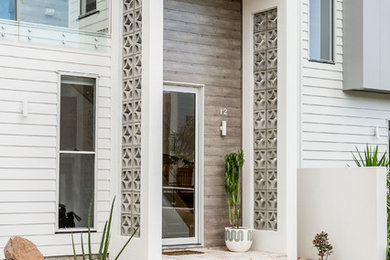 Inspiration for a beach style front door in Sunshine Coast with a single front door and a glass front door.