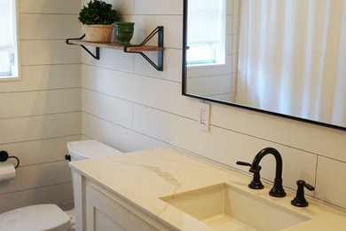 Example of a mid-sized danish 3/4 white tile and subway tile slate floor and black floor bathroom design in Houston with furniture-like cabinets, white cabinets, white walls, an undermount sink, marble countertops and a two-piece toilet