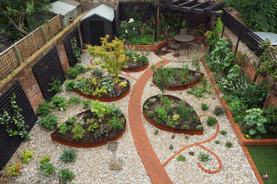 Design ideas for a contemporary backyard formal garden in Kent with a container garden and gravel.