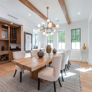 This is an example of a country open plan dining in Los Angeles with white walls, light hardwood floors and beige floor.