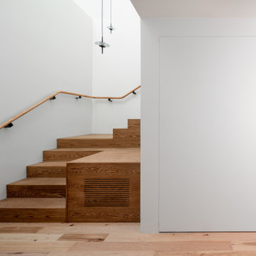 Bottom of stair with hidden pivot door closed.