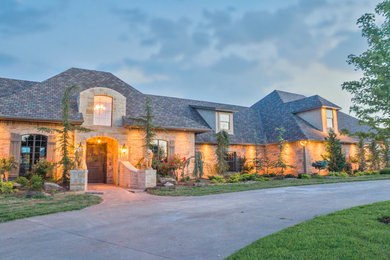Example of a large classic red split-level brick exterior home design in Oklahoma City with a clipped gable roof
