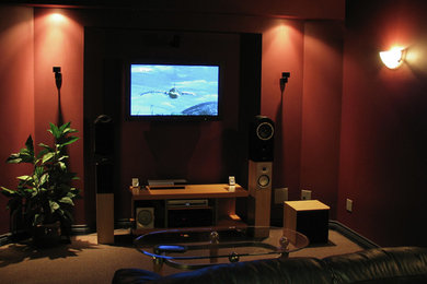 Inspiration for a mid-sized enclosed carpeted home theater remodel in Calgary with red walls and a wall-mounted tv