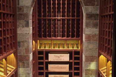 Design ideas for a mid-sized traditional wine cellar in Atlanta with terra-cotta floors, display racks and brown floor.