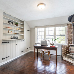 Inspiration for a country study room in Philadelphia with grey walls, a wood stove, a brick fireplace surround, a freestanding desk and brown floor.