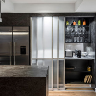 Photo of a mid-sized modern galley kitchen pantry in Brisbane with an undermount sink, flat-panel cabinets, wood benchtops, metallic splashback, mirror splashback, stainless steel appliances, light hardwood floors and with island.