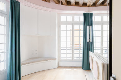 Cette image montre un petit salon design avec un mur blanc, parquet clair, aucune cheminée, un plafond en bois et éclairage.