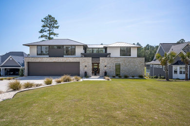 Large modern two-story concrete fiberboard house exterior idea in Other with a metal roof and a black roof