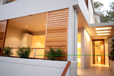 This is an example of a small contemporary three-storey concrete white exterior in Sydney.