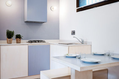 Small beach style l-shaped eat-in kitchen in Other with flat-panel cabinets, grey floor, white benchtop, blue cabinets, blue splashback, a drop-in sink and no island.
