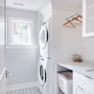 ミネアポリスの小さいトランジショナルスタイルのおしゃれな洗濯室 (セラミックタイルの床、上下配置の洗濯機・乾燥機、アンダーカウンターシンク、シェーカースタイル扉のキャビネット、白いキャビネット、グレーの壁、マルチカラーの床、白いキッチンカウンター) の写真