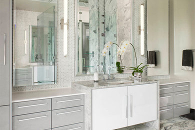 Inspiration for an expansive modern master bathroom in Dallas with an undermount sink, grey cabinets, quartzite benchtops, a drop-in tub, an open shower, a wall-mount toilet, gray tile, stone tile, grey walls, marble floors and flat-panel cabinets.