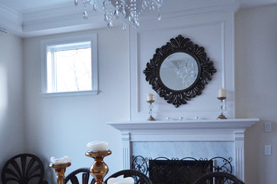 Elegant dining room photo in Calgary with white walls, a standard fireplace and a stone fireplace