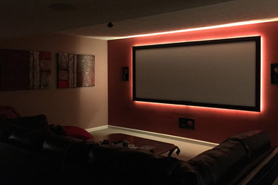 Example of a mid-sized classic enclosed carpeted and beige floor home theater design in Indianapolis with multicolored walls and a projector screen