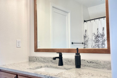 Example of a large master white tile and ceramic tile ceramic tile, white floor and single-sink bathroom design in Minneapolis with flat-panel cabinets, medium tone wood cabinets, a two-piece toilet, white walls, an undermount sink, granite countertops, white countertops and a built-in vanity