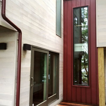 Two-storey window and standing seam roof / siding demarcate upper & lower levels