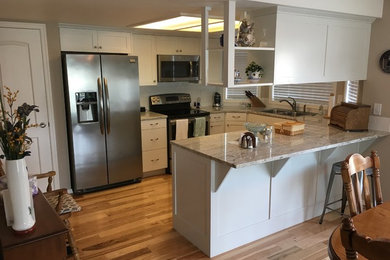 Eat-in kitchen - small craftsman u-shaped bamboo floor and brown floor eat-in kitchen idea in Boise with a double-bowl sink, shaker cabinets, white cabinets, quartzite countertops, white backsplash, subway tile backsplash, stainless steel appliances and a peninsula