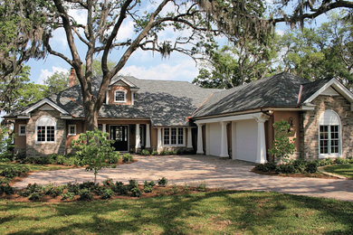 Mid-sized elegant brown one-story stucco exterior home photo in Miami with a hip roof
