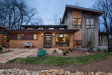 Brown three-story wood house exterior photo in Other with a shed roof and a metal roof