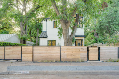 Mid-sized country white two-story glass and board and batten house exterior photo in Austin with a metal roof and a black roof