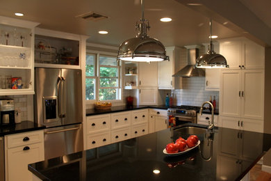 Large elegant u-shaped ceramic tile kitchen photo in Los Angeles with an undermount sink, flat-panel cabinets, white cabinets, granite countertops, white backsplash, subway tile backsplash, stainless steel appliances and an island