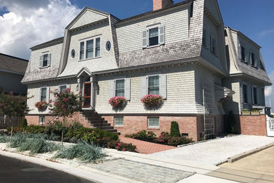 Large beach style gray two-story wood house exterior photo in Other with a gambrel roof and a shingle roof
