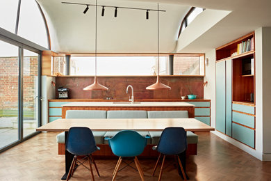 Inspiration for a medium sized midcentury kitchen/dining room in Sussex with blue walls, dark hardwood flooring, brown floors, a vaulted ceiling, wood walls and feature lighting.