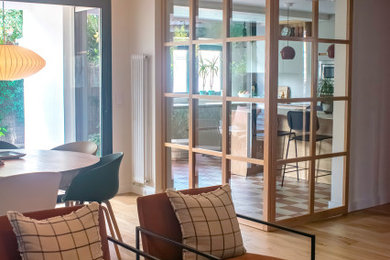Ejemplo de salón contemporáneo de tamaño medio con suelo de madera en tonos medios, todas las chimeneas y marco de chimenea de piedra