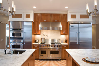 Photo of an arts and crafts kitchen in New York with an undermount sink, shaker cabinets, medium wood cabinets, marble benchtops, stone tile splashback and stainless steel appliances.