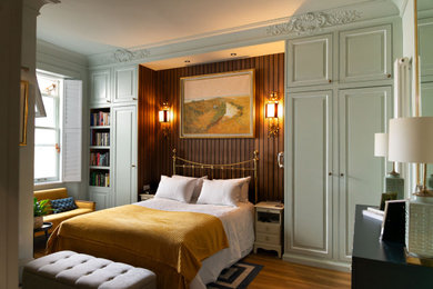 Imagen de dormitorio principal clásico de tamaño medio con paredes azules, suelo de madera en tonos medios, suelo marrón y panelado
