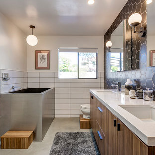 Mid-Century Badezimmer En Suite mit flächenbündigen Schrankfronten, dunklen Holzschränken, Eckbadewanne, bodengleicher Dusche, Toilette mit Aufsatzspülkasten, schwarzer Wandfarbe, Betonboden, Unterbauwaschbecken, grauem Boden, offener Dusche und weißen Fliesen in Phoenix